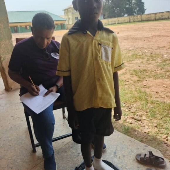 Fascilitator conducting baseline assessment with a pupil at LEA Primary School UTAKO